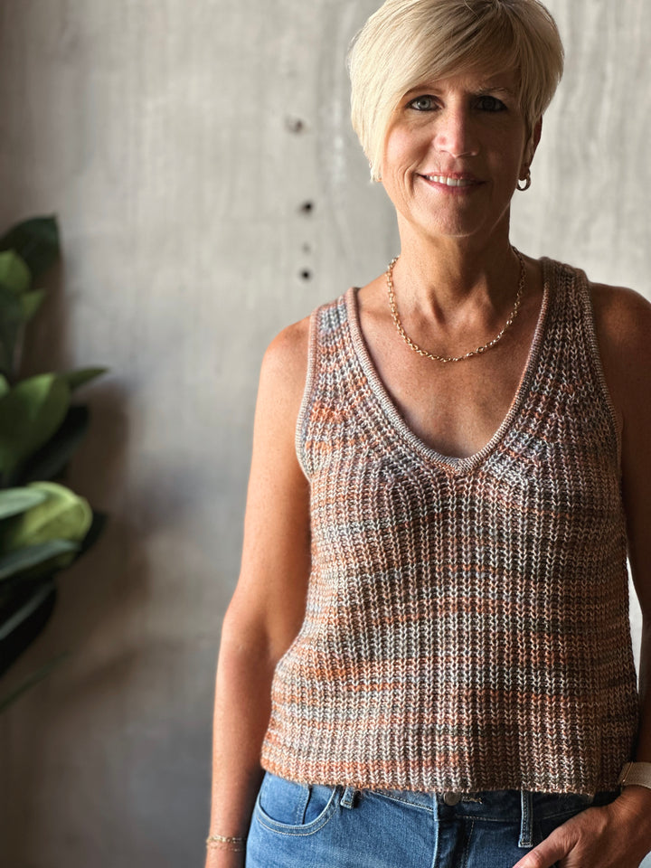 Woman wearing a patterned sleeveless top against a neutral background