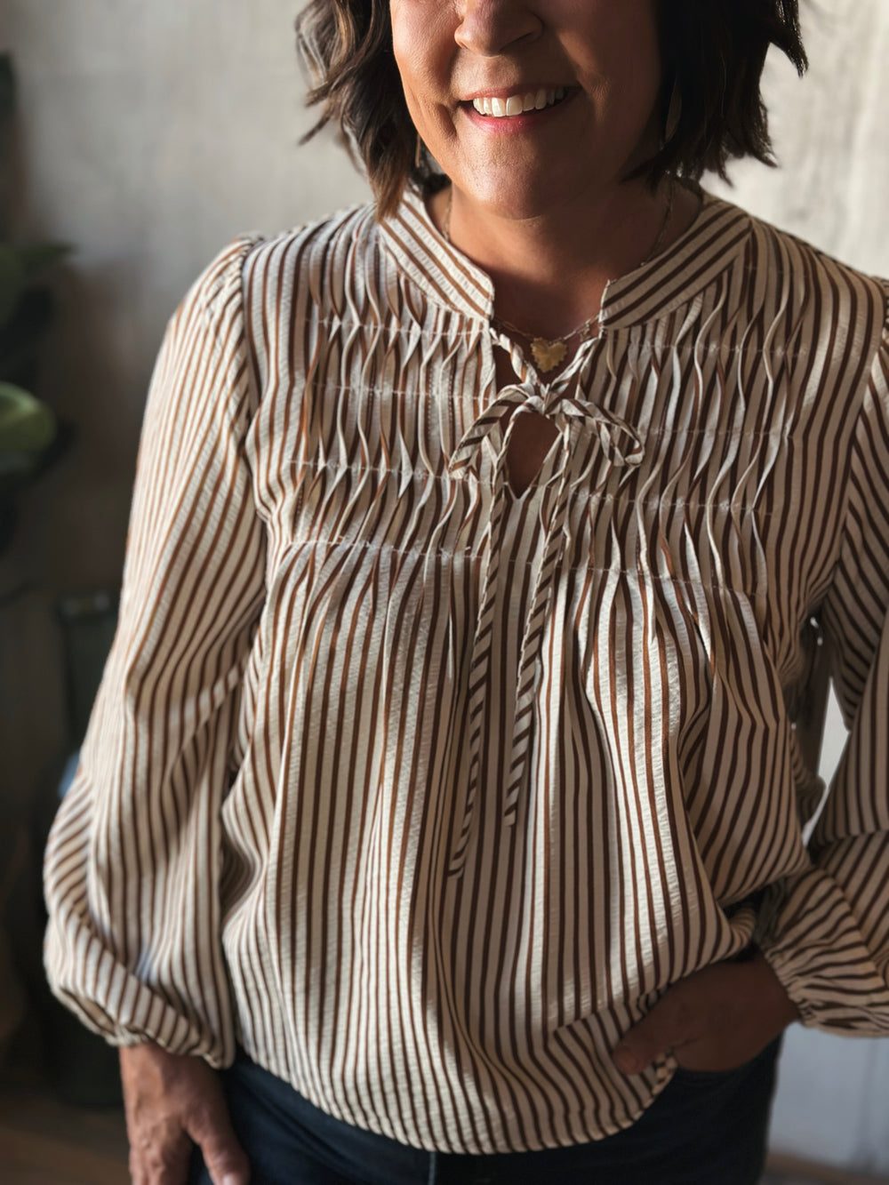 Woman wearing a striped blouse with a blurred background