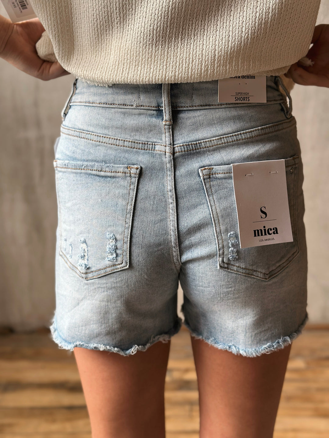 Denim shorts with a brand tag on a neutral background