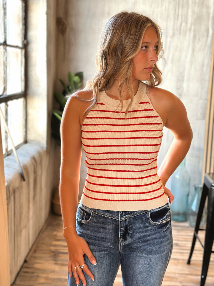 Woman wearing a striped tank top and jeans indoors