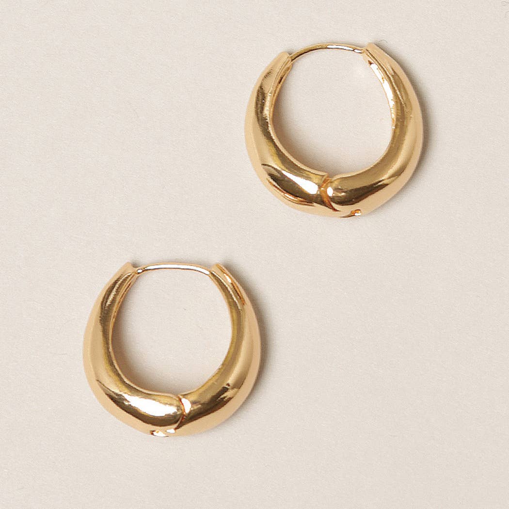 Gold hoop earrings on a beige background