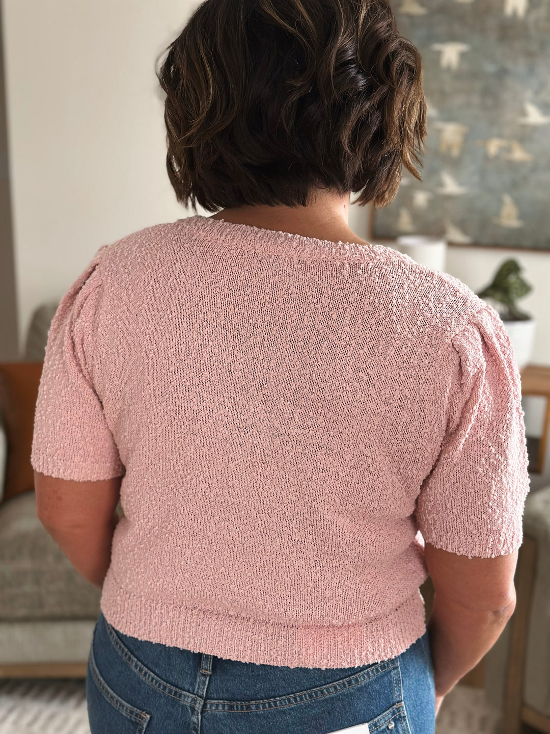 Back of person wearing a pink textured sweater.