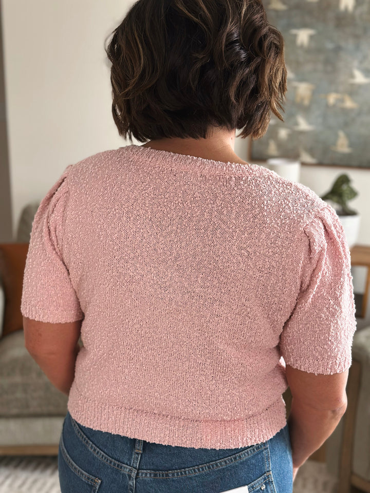 Back of person wearing a pink textured sweater.