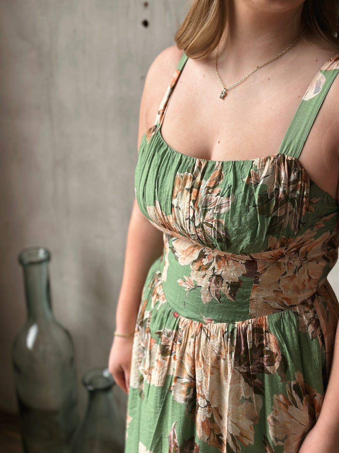 Woman wearing a green floral dress with a blurred background