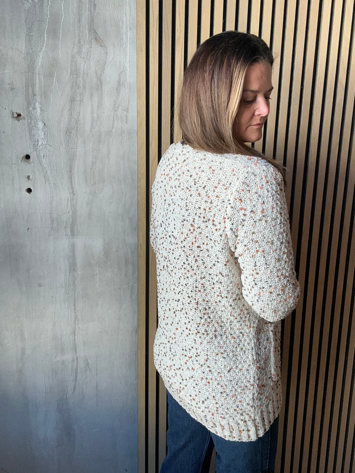 Back view of a cream speckled-knit cardigan
