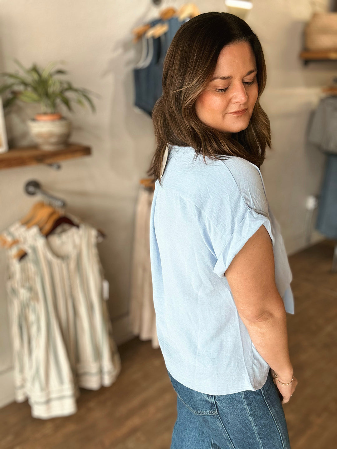 Woman wearing a light blue shirt in a clothing store