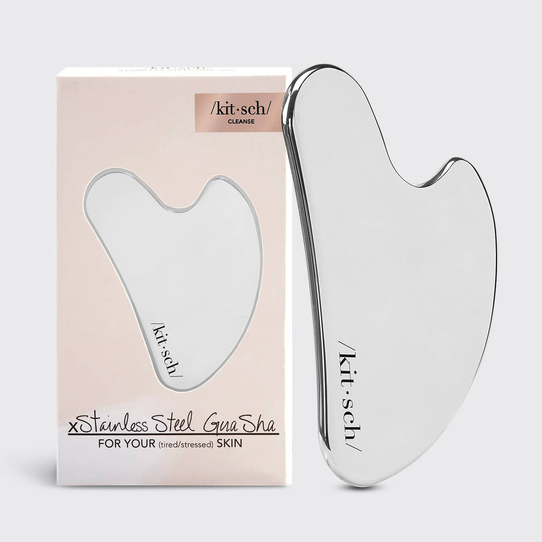 Silver Gua Sha tool with 'kit-sch' branding next to its packaging on a white background