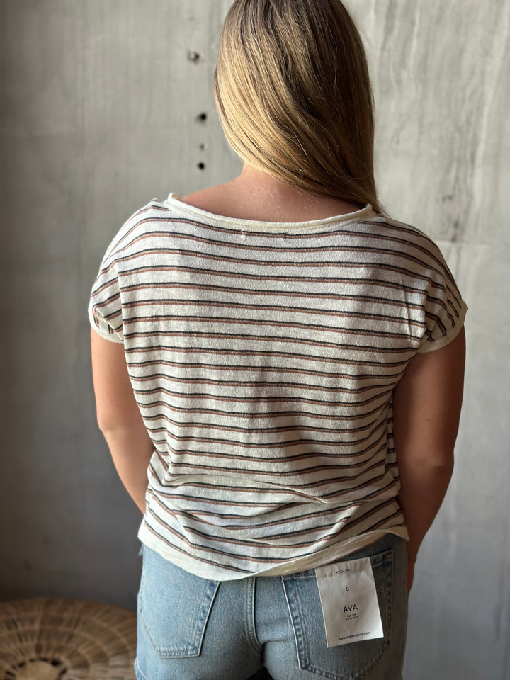 A person wearing a white and brown striped shirt. 