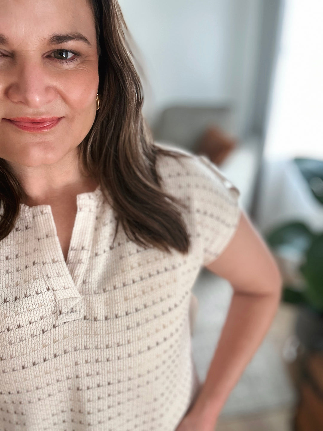 Woman wearing a textured white patterned top in an indoor setting