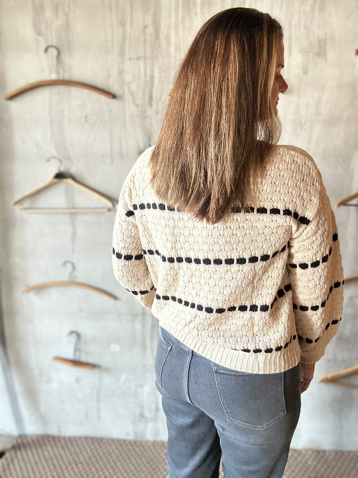 Back view of a cream sweater with black bobble stripes