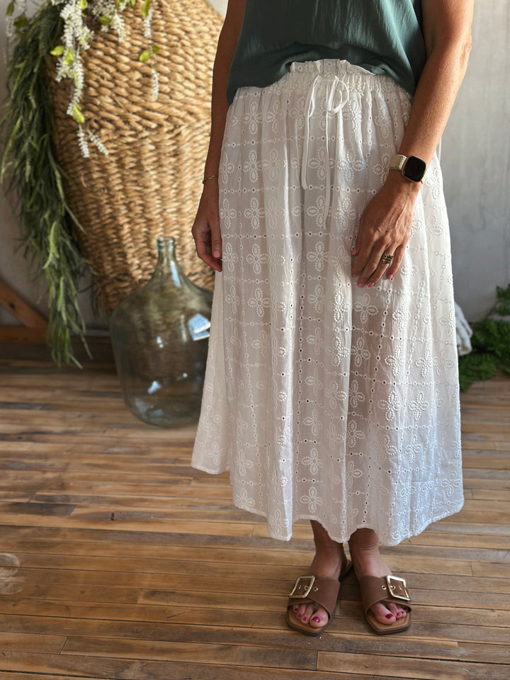 front view white eyelet midi skirt,  Featuring a high elastic waist with a front tie drawstring, delicate ruffle trim, and a classic eyelet pattern.