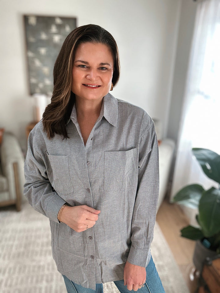 Woman wearing a gray striped shirt in a home setting