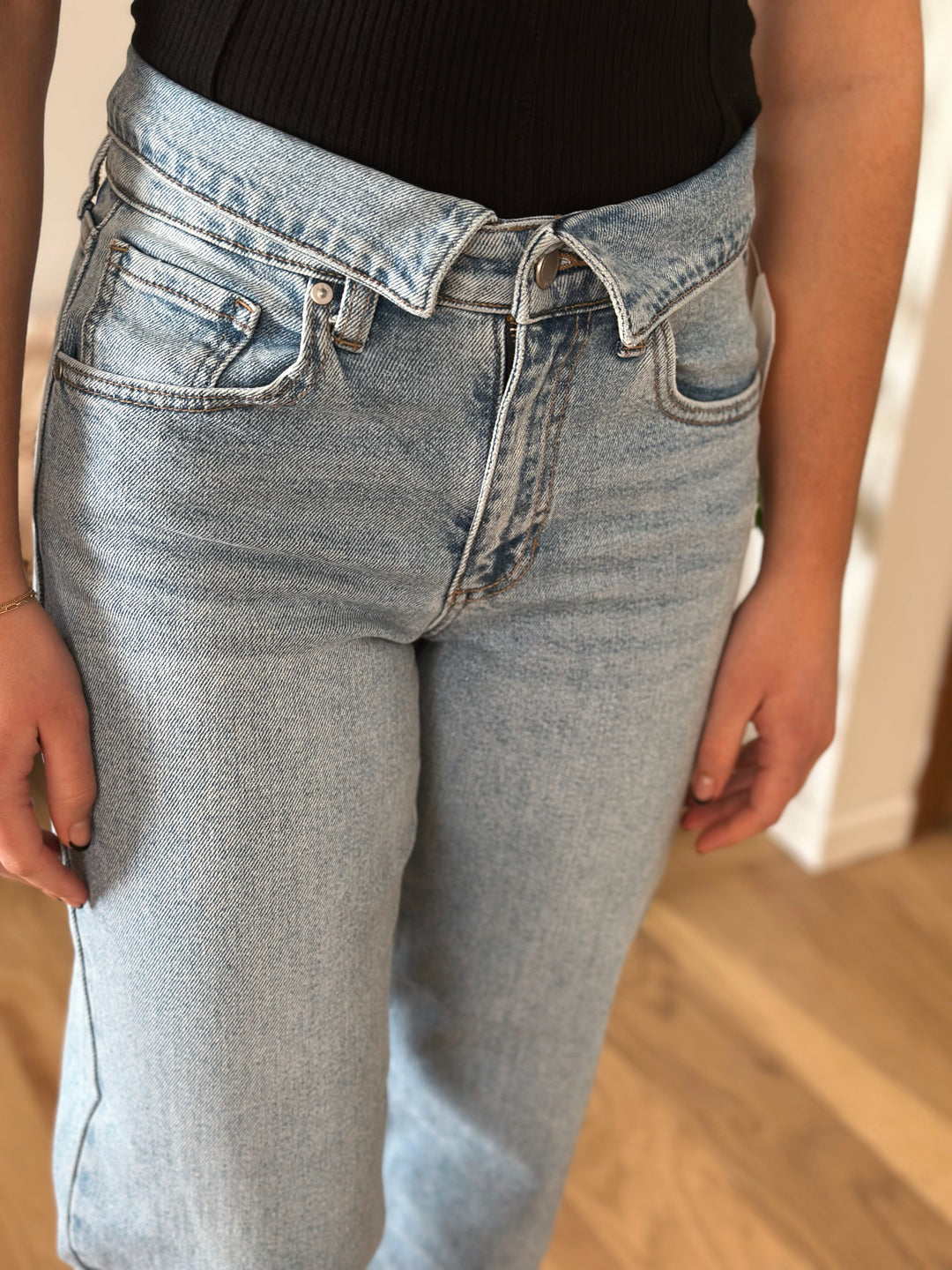 Person wearing light blue jeans with a blurred background