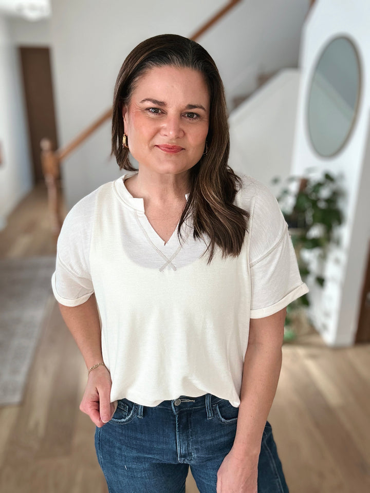 Woman wearing a white t-shirt and blue jeans indoors
