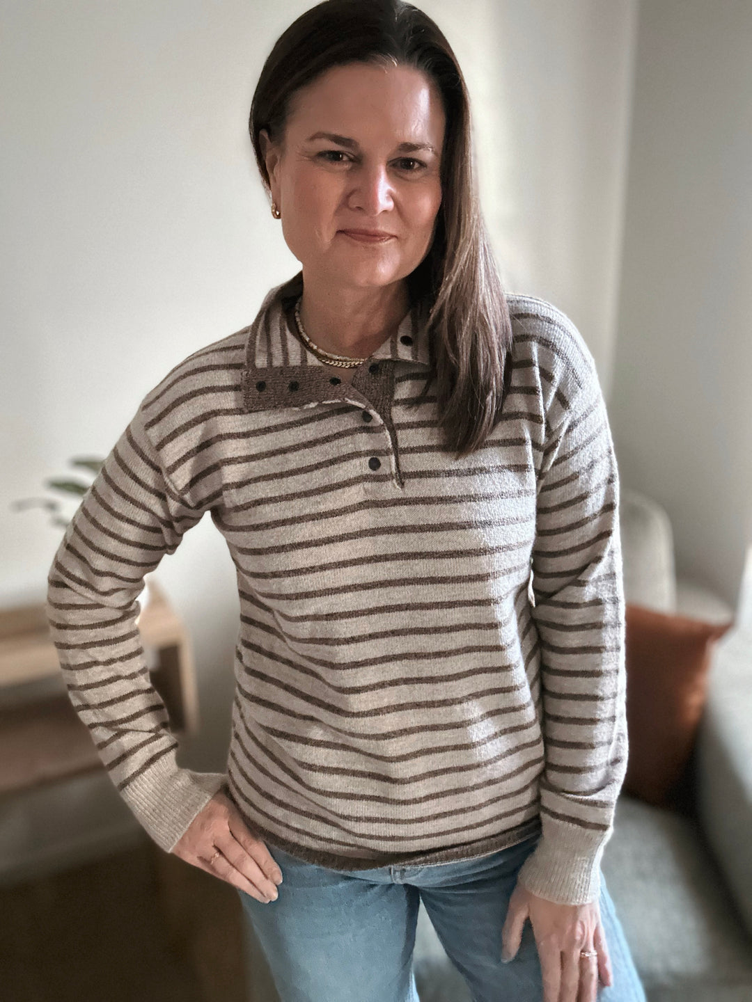 Woman wearing a striped sweater in a casual indoor setting