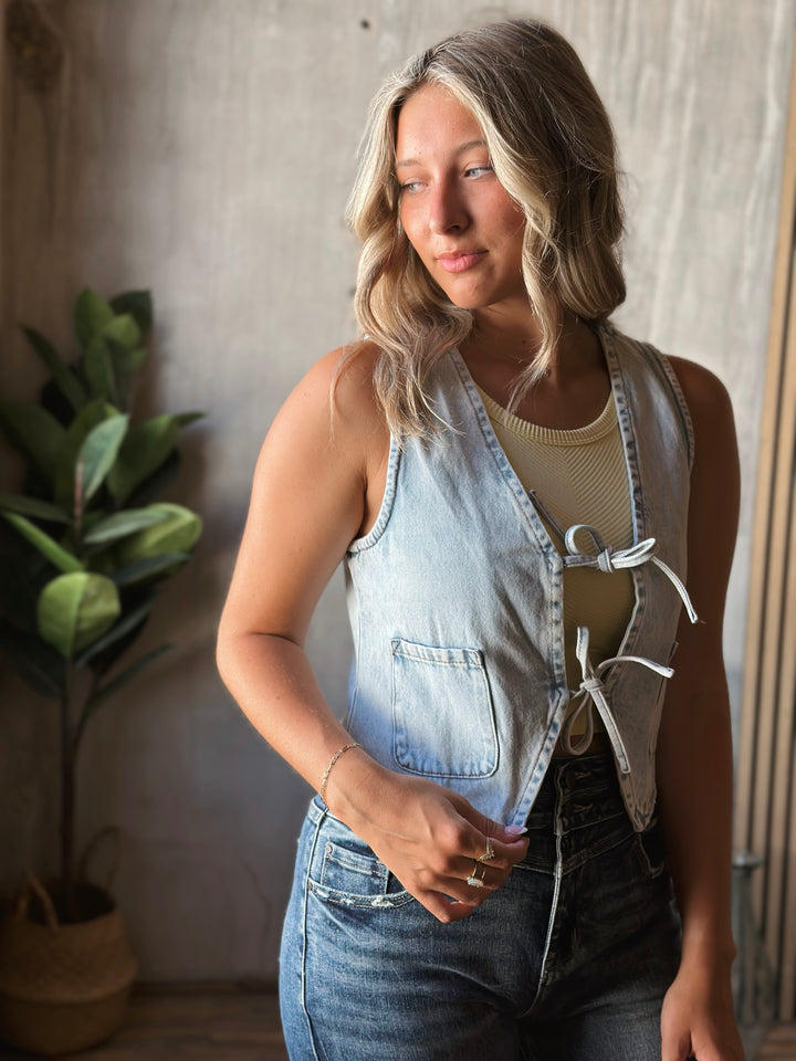 Woman wearing a denim overalls with a neutral background