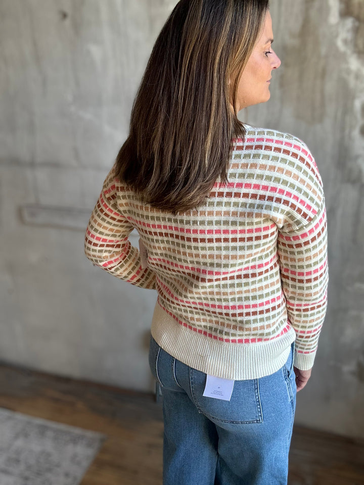 Back view of a cream multicolor striped crewneck sweater