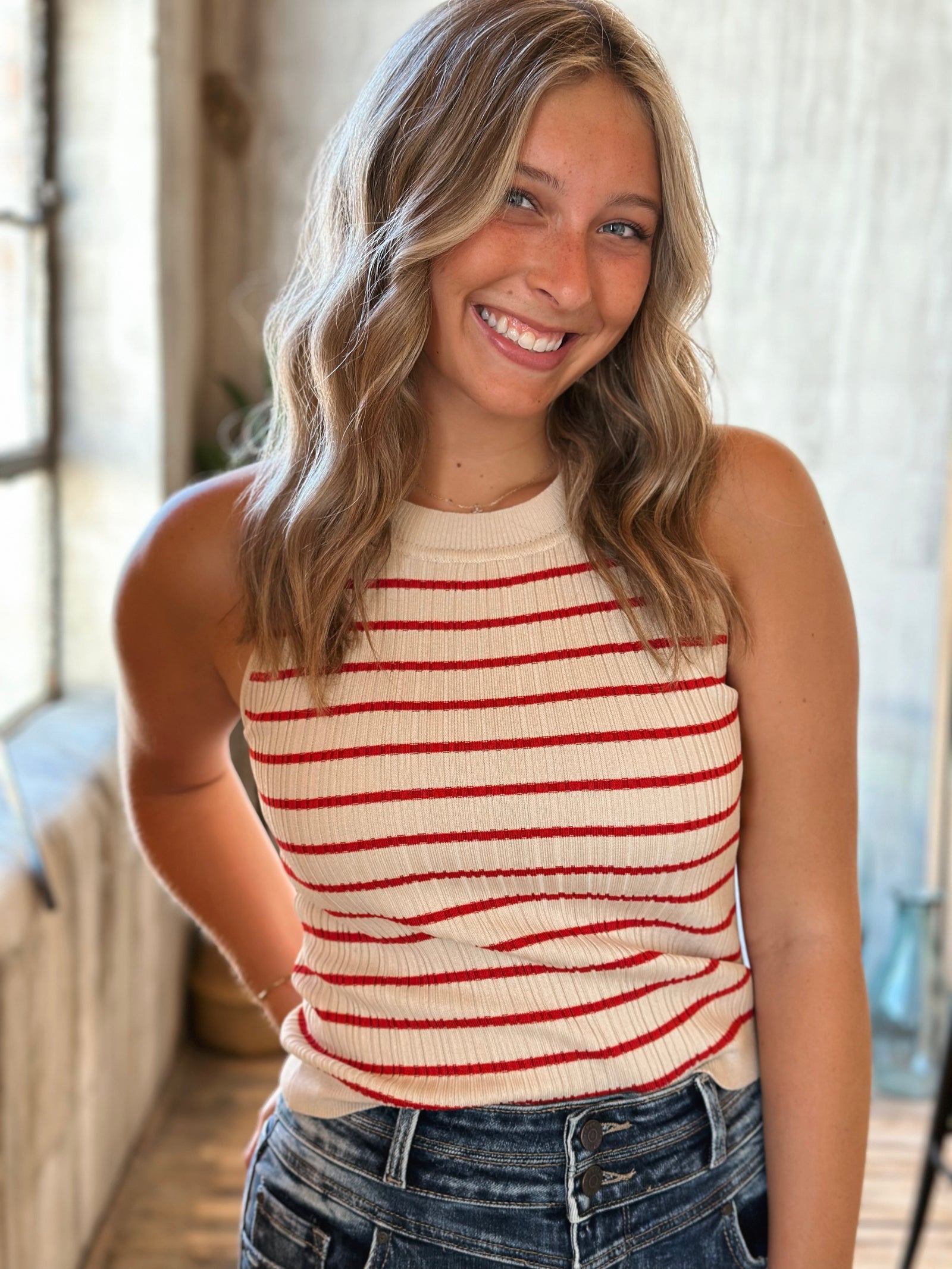 Woman wearing a striped sleeveless top in a bright indoor setting