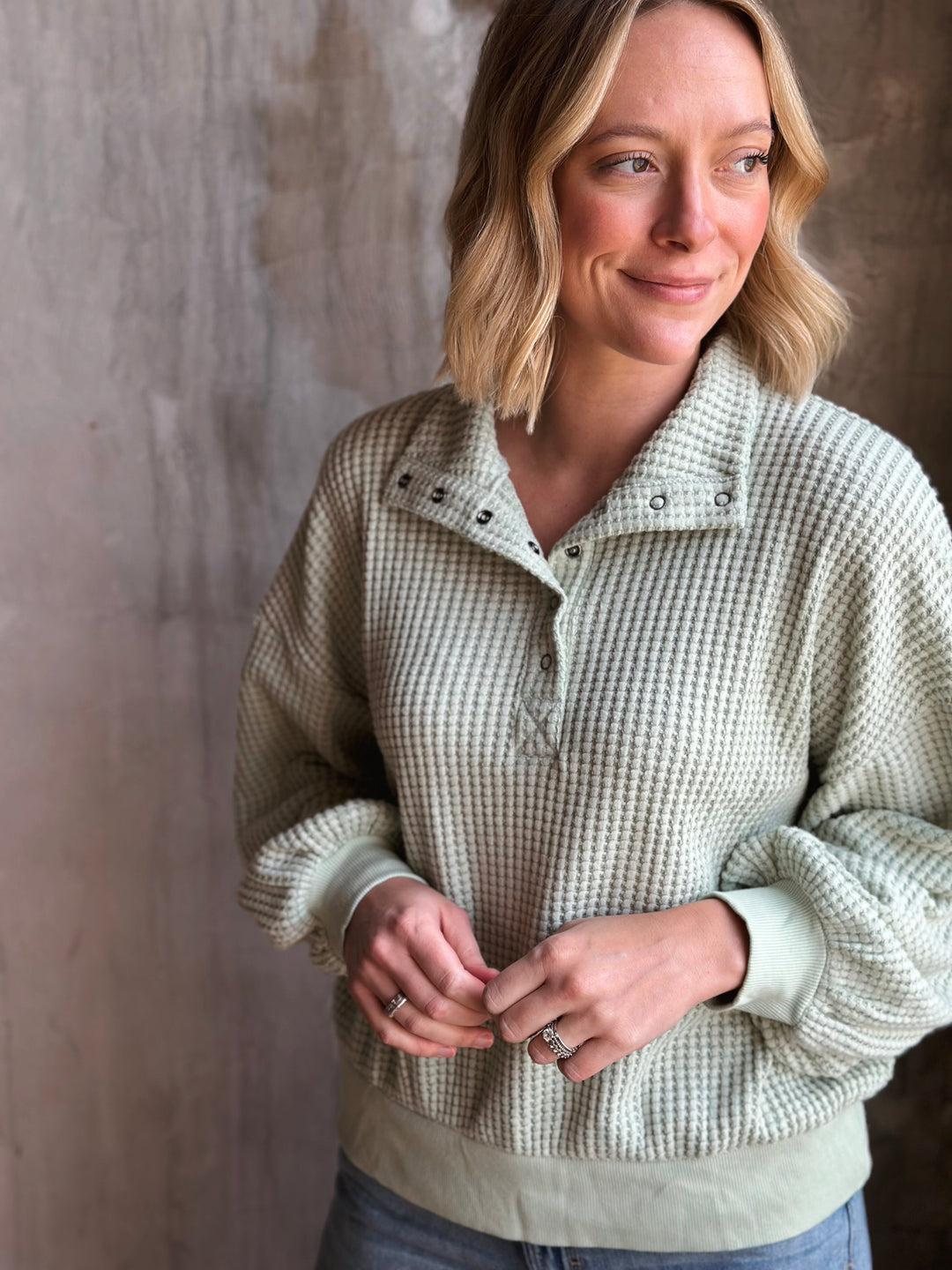 Woman wearing a checkered shirt against a neutral background