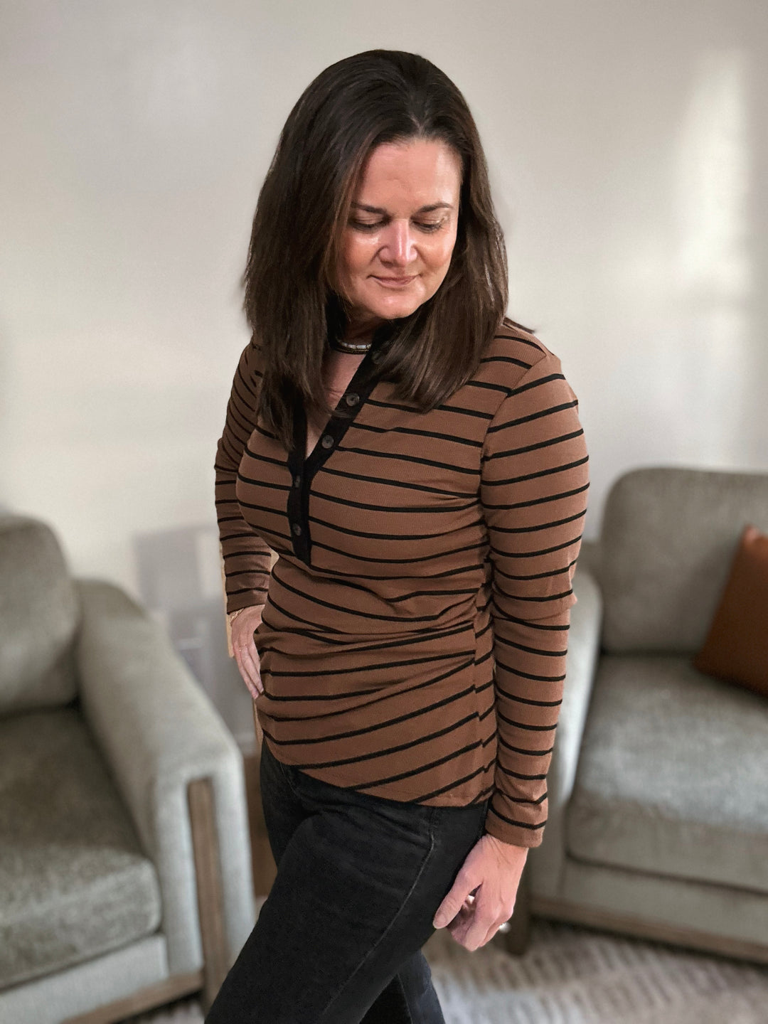 Woman wearing a brown striped shirt in a living room setting