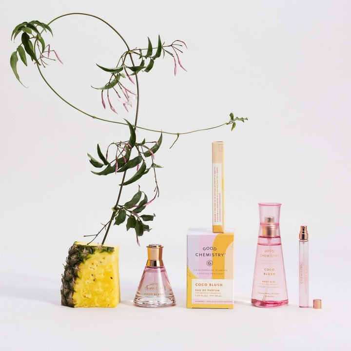 Perfume bottles and a pineapple with a plant on a light background