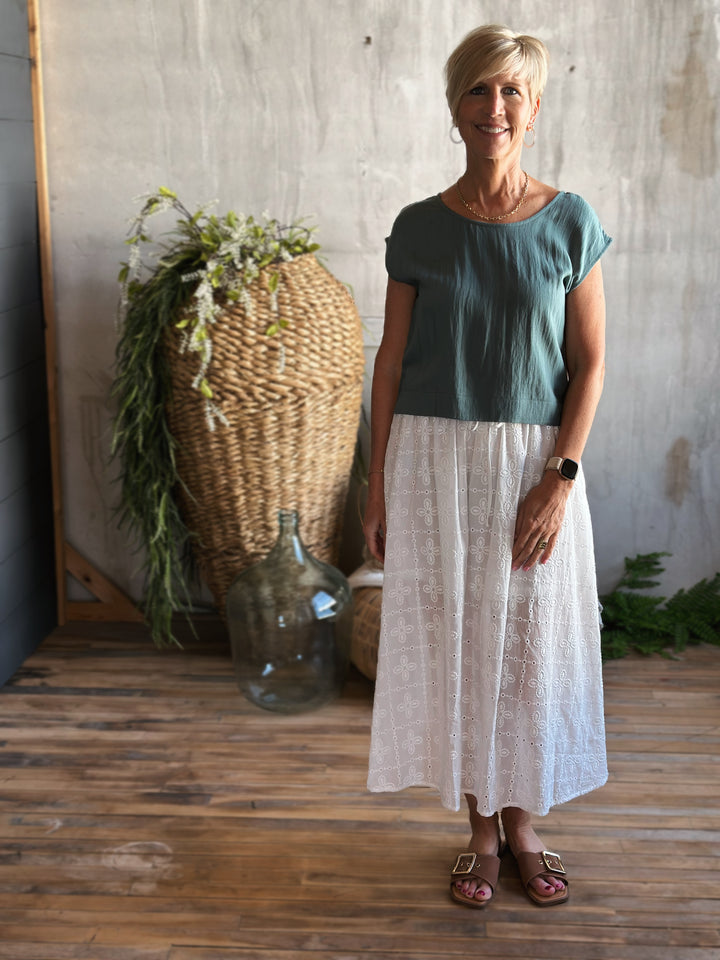front view white eyelet midi skirt,  Featuring a high elastic waist with a front tie drawstring, delicate ruffle trim, and a classic eyelet pattern.