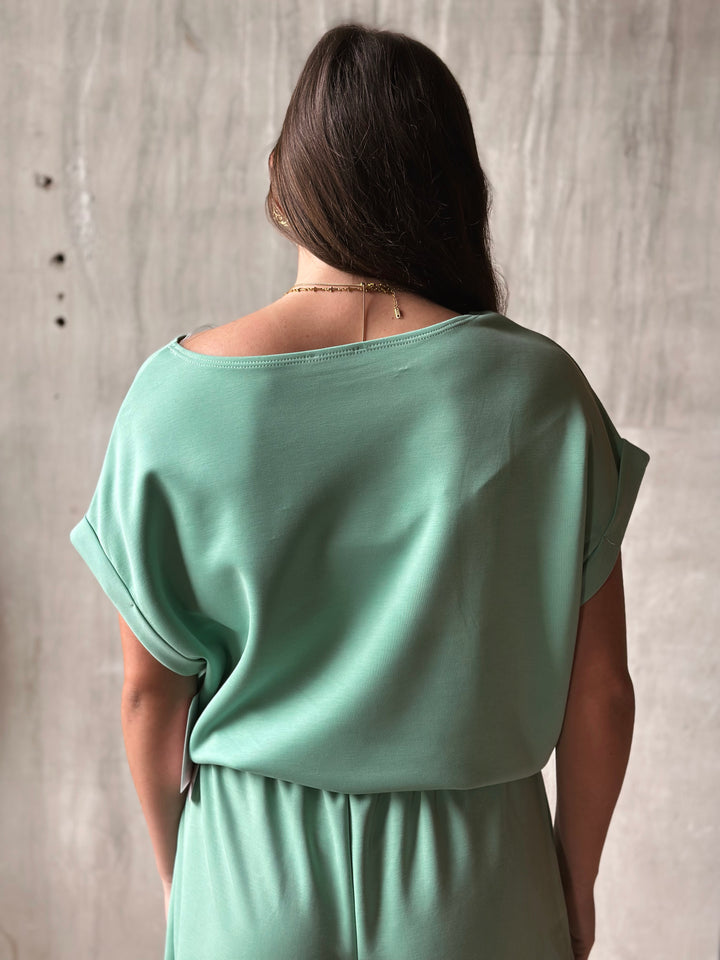 Woman wearing a light green dress against a plain background