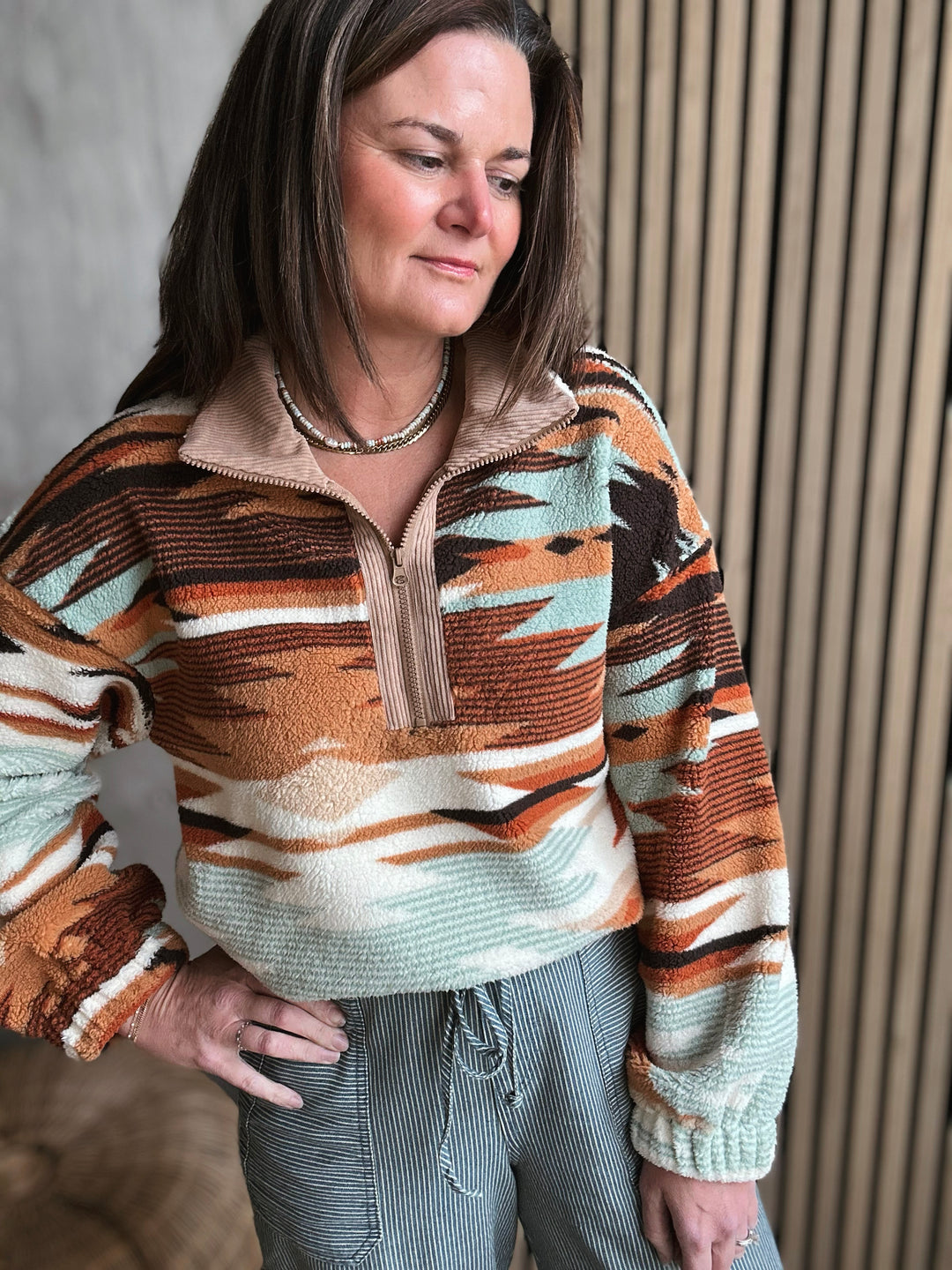 Person wearing a patterned sweater with a neutral background