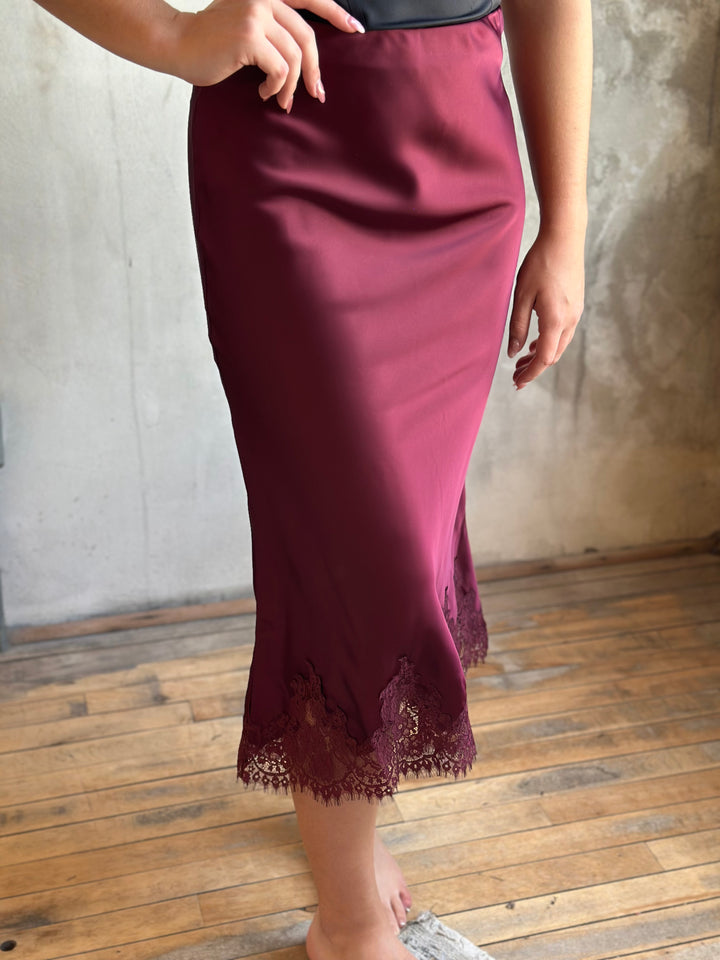 Burgundy satin midi skirt with a lace-trimmed hem, side view