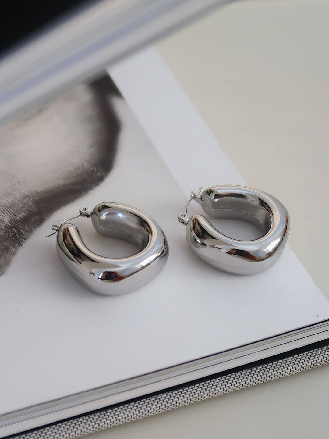 Silver hoop earrings on a magazine