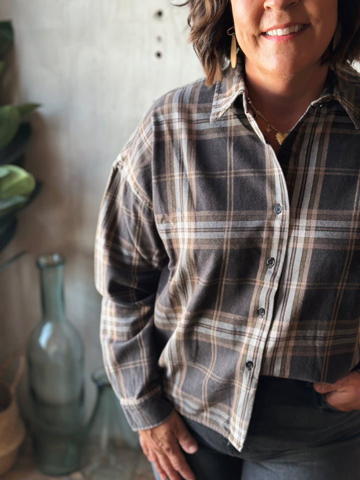 Person wearing a plaid shirt in an indoor setting with a neutral background