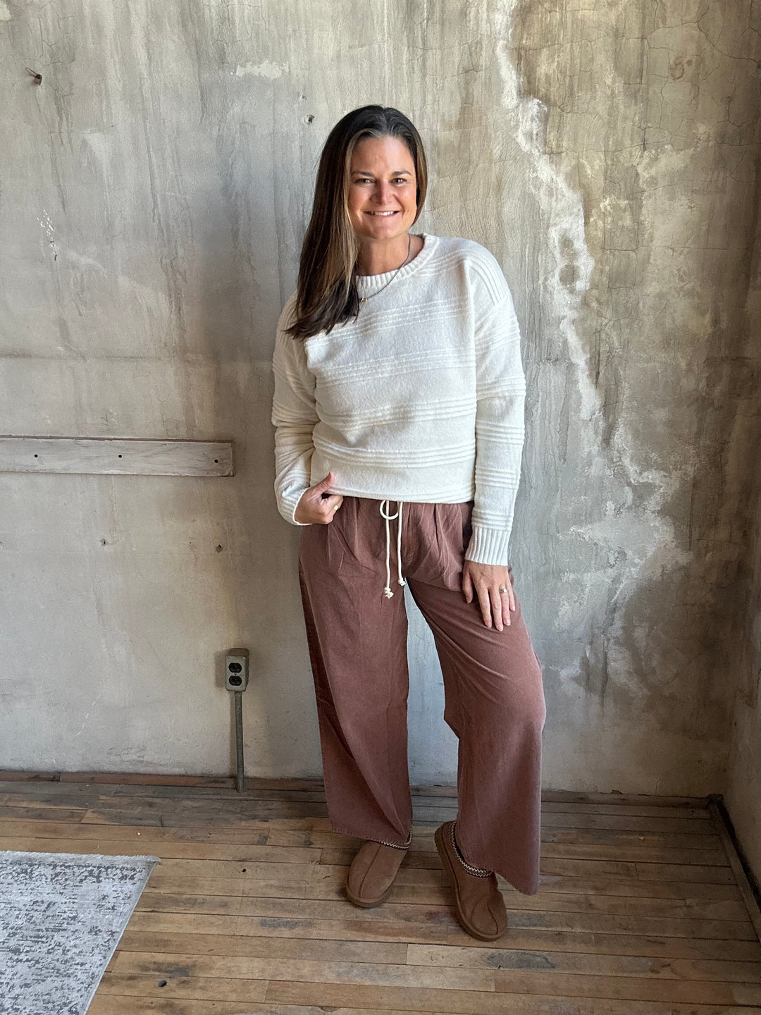Woman wearing dusty rose wide-leg drawstring pants with a cream sweater, full-length view