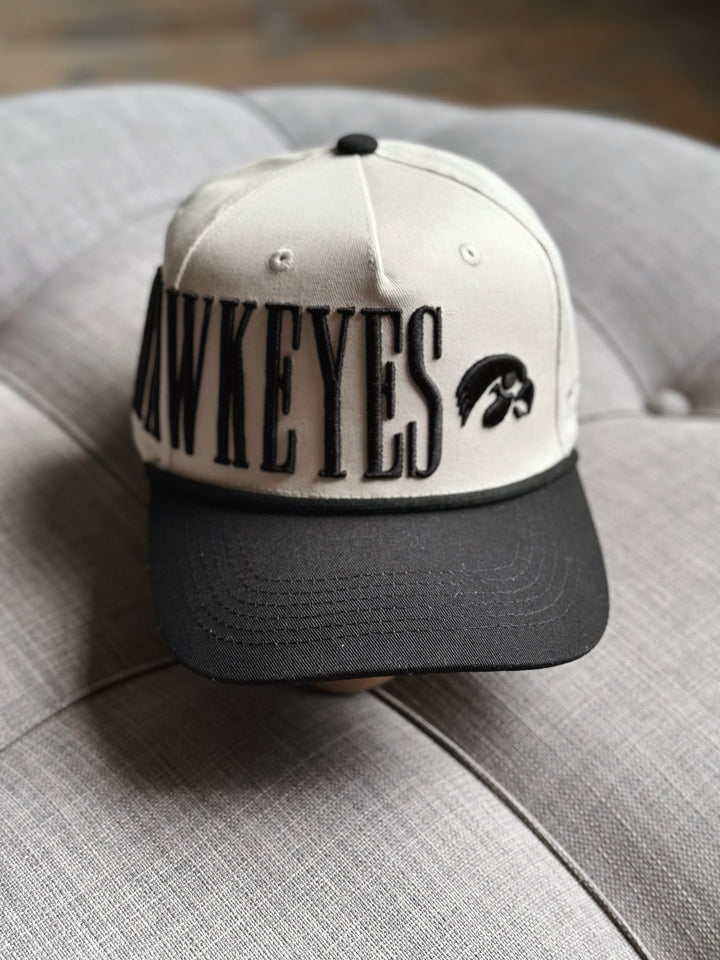 Baseball cap with 'Hawkeyes' and logo on a gray surface