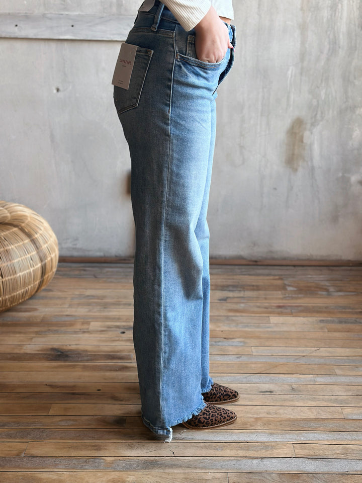 A person wearing light blue jeans with leopard print boots. 