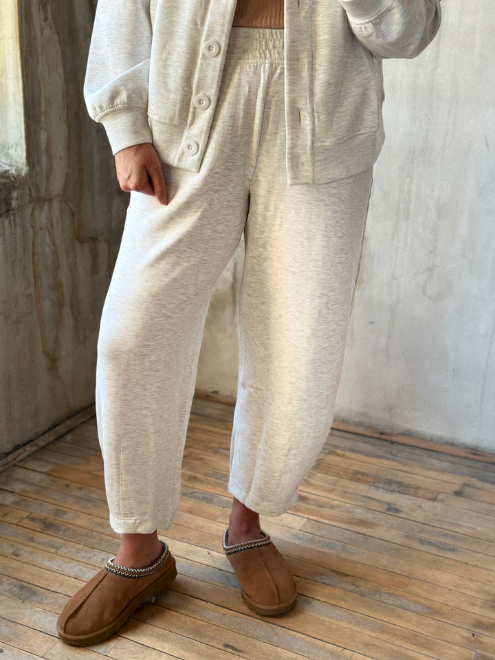 Cream heathered barrel-leg pants with tan slippers, front view