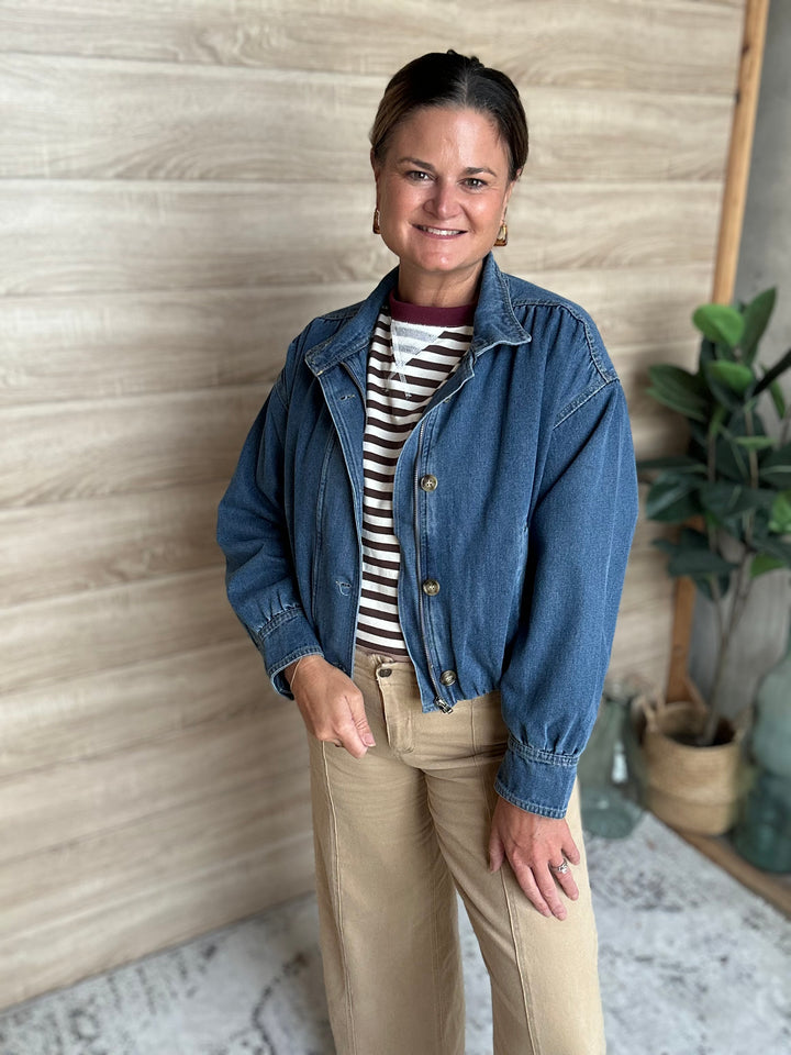 A woman wearing a puffy blue denim jacket with buttons down the middle.