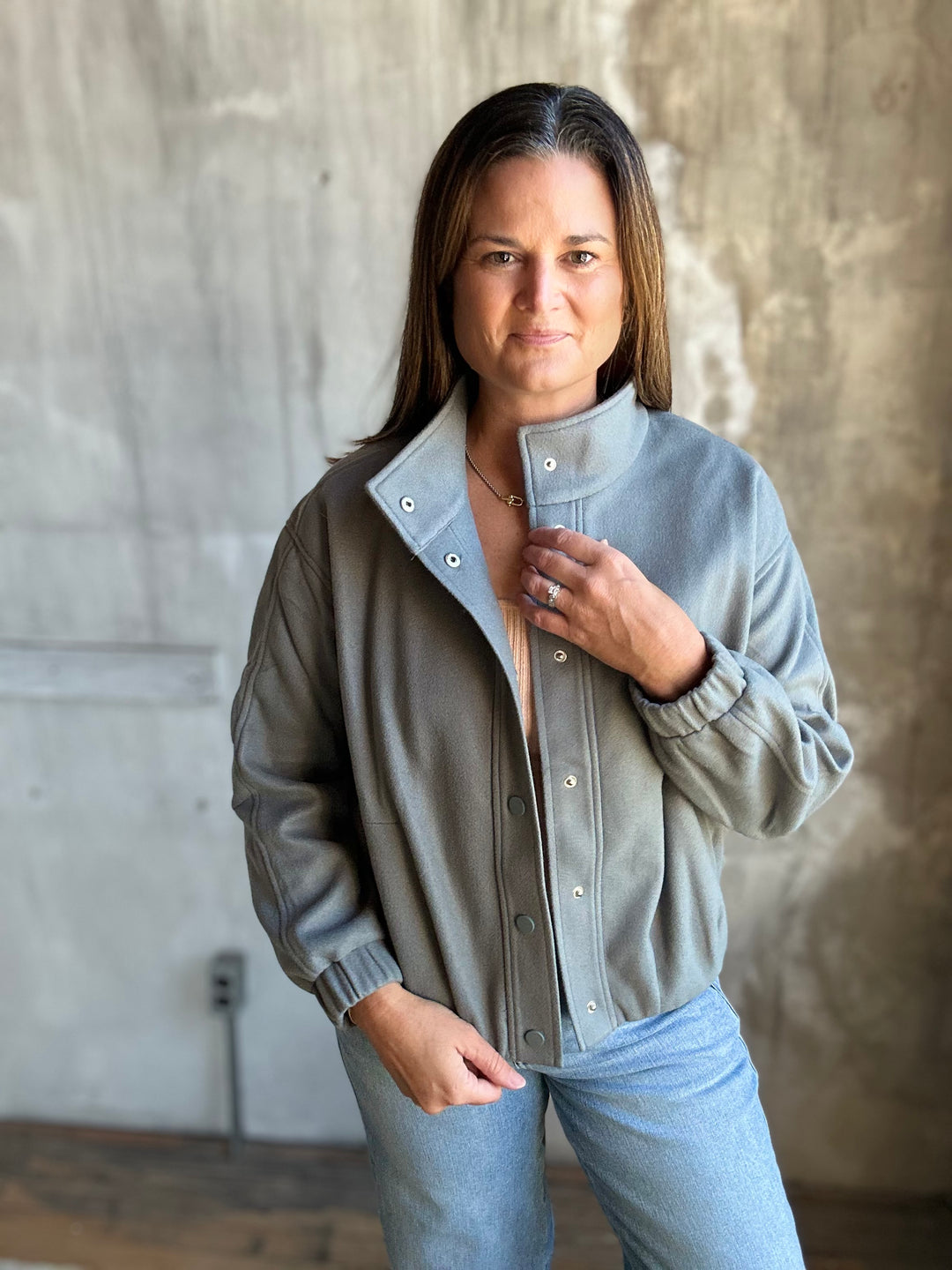 Slate blue snap-front jacket with an elastic hem, styled with light-wash jeans
