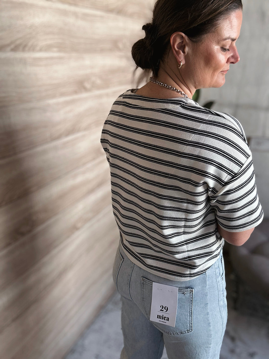A woman wearing a short sleeved black and white striped shirt. 