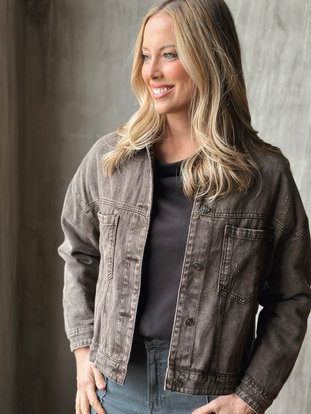 Woman wearing a denim jacket against a neutral background