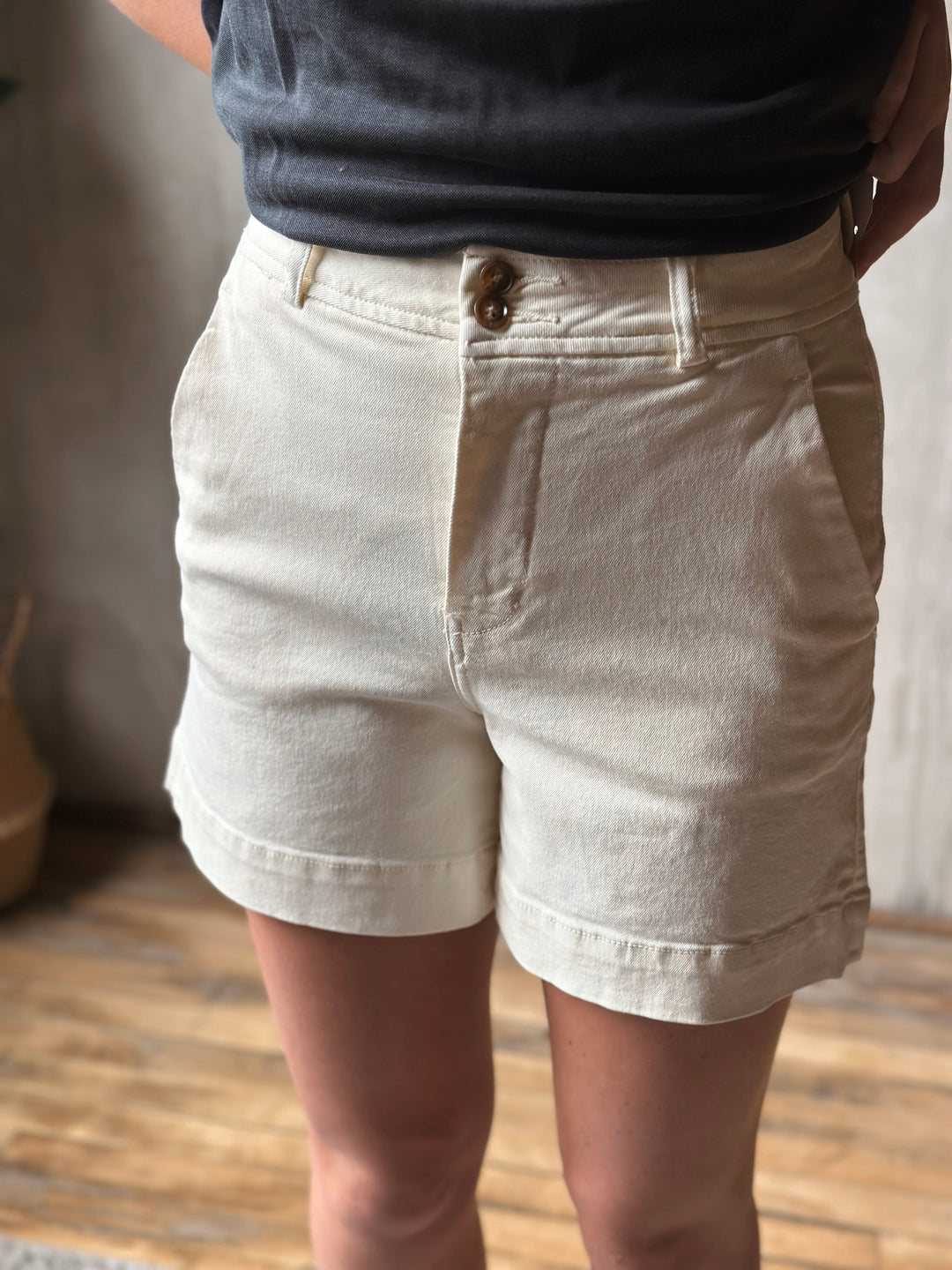 Person wearing light-colored shorts with a blurred background
