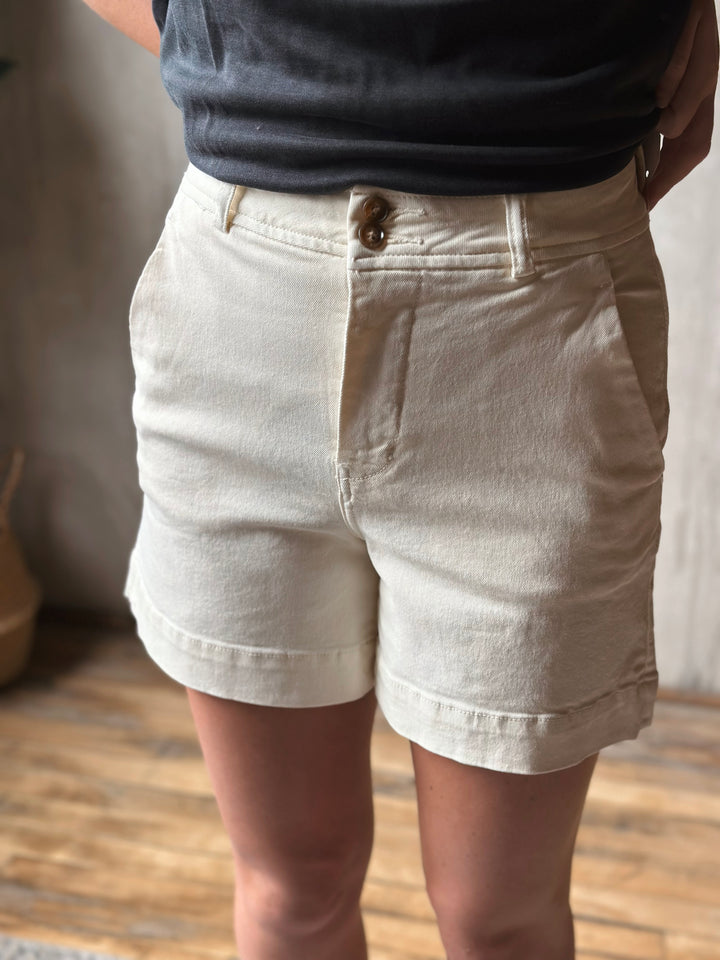 Person wearing light-colored shorts with a blurred background