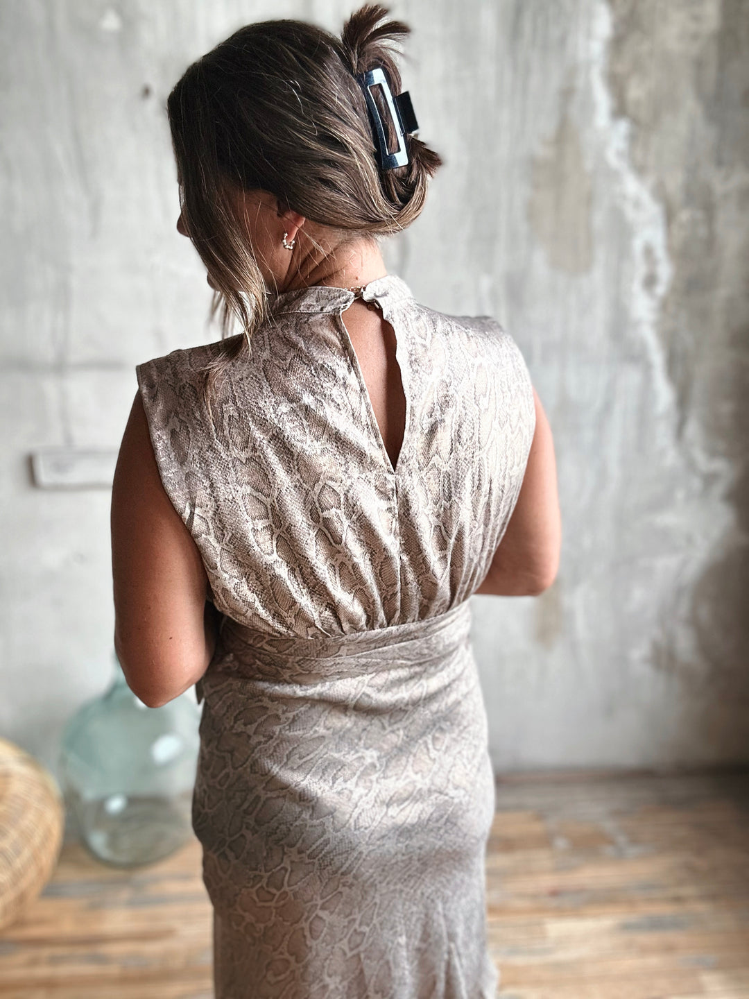 Woman wearing a patterned dress with a neutral background