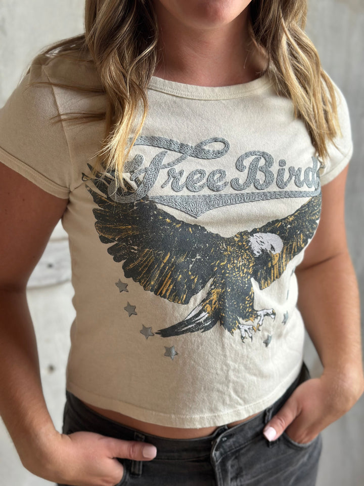 Close-up of a cream fitted tee with a Free Bird eagle print