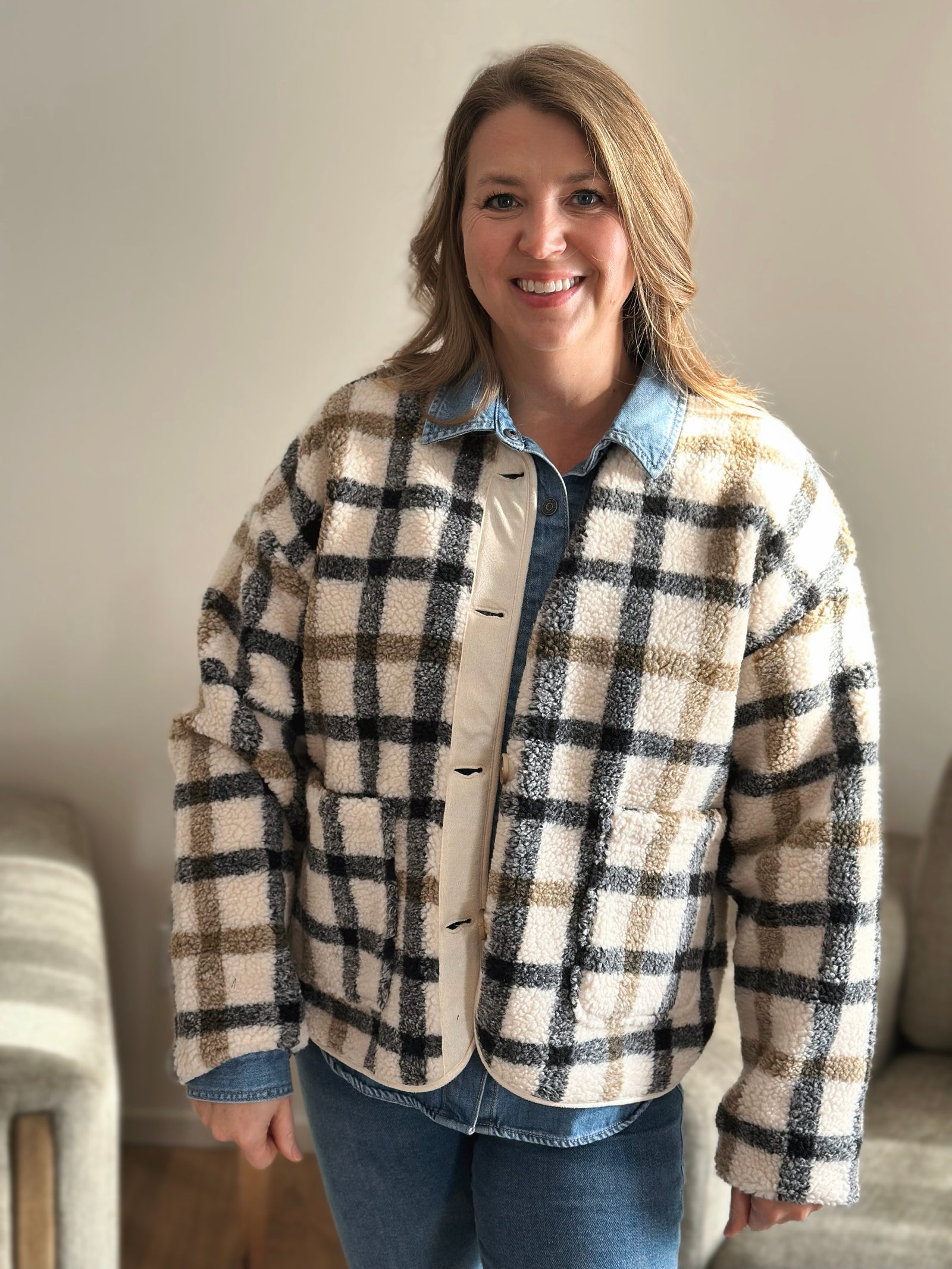Woman wearing a plaid jacket in a home setting