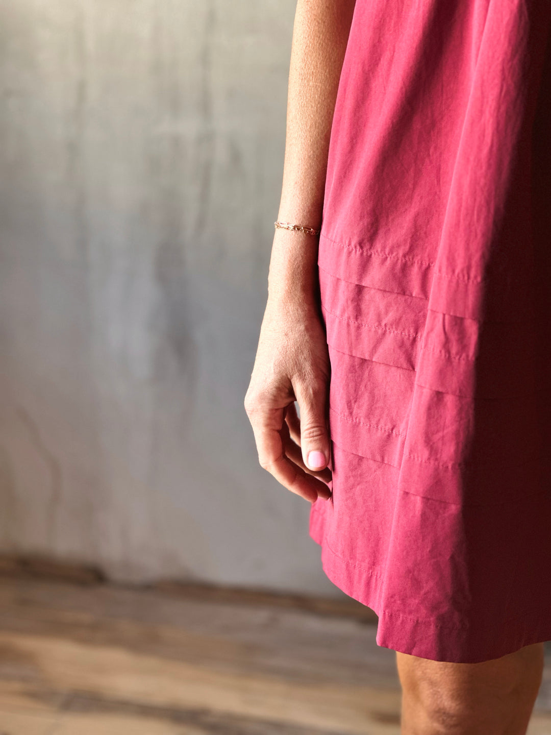 Close up Front view of mini dress features a  pleated hemline. Deep Plum. 