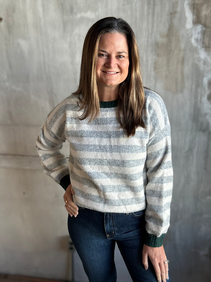 Gray and cream striped sweater with contrast neckline, styled with dark jeans
