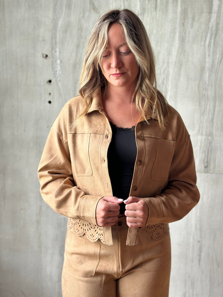 Woman wearing a tan suede-look shirt jacket with a laser-cut hem over a black tank