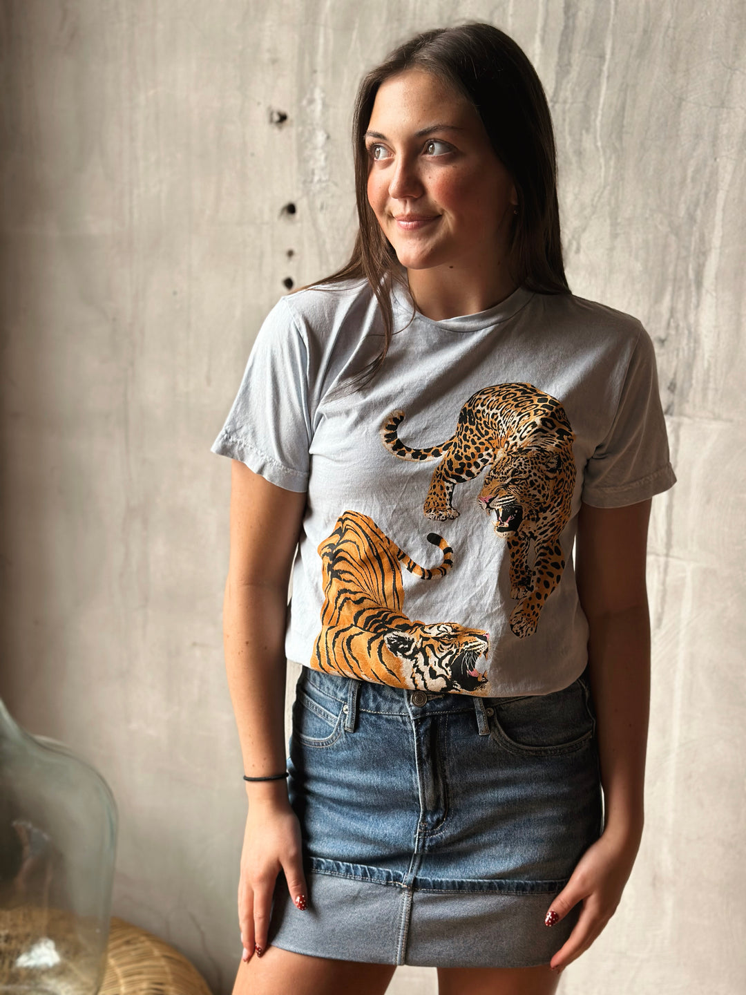 Woman wearing a t-shirt with a tiger design against a neutral background.
