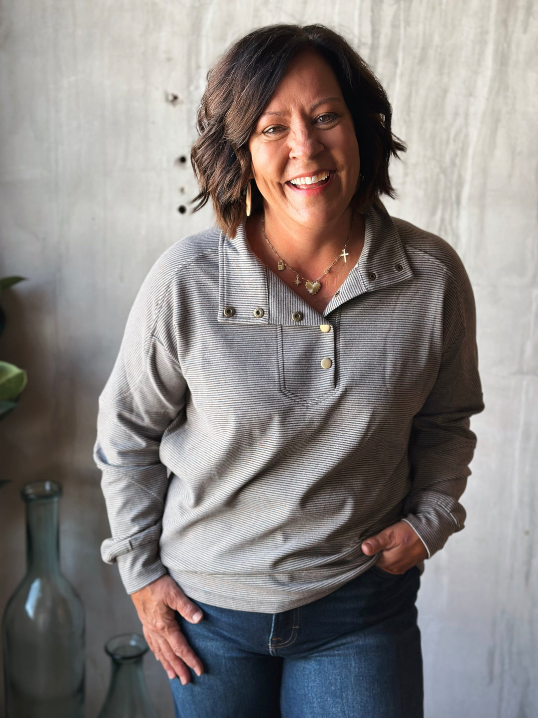 Woman wearing a gray sweater with a neutral background