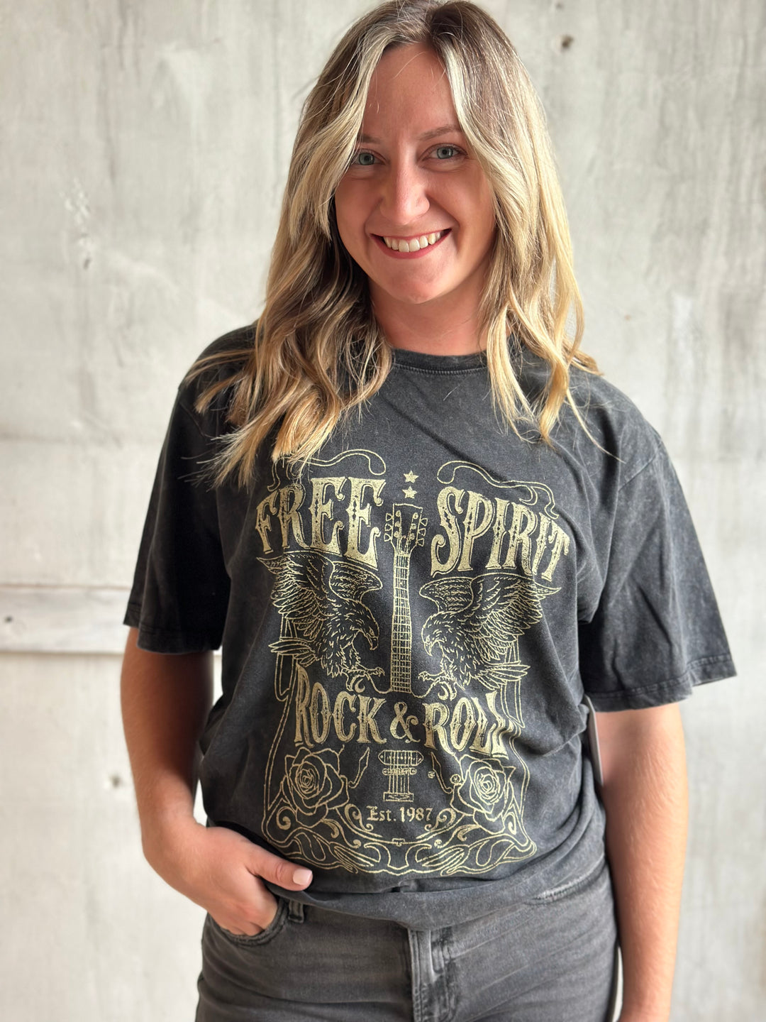 Woman wearing a charcoal Free Spirit graphic tee with gray jeans